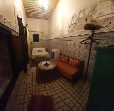 a bathroom with a couch and a bed in a room at Dar Pa Labzioui in Meknès