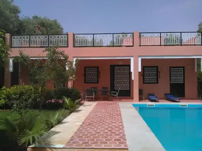 a house with a swimming pool in front of it at Riad Marrakech Ourika in Marrakech