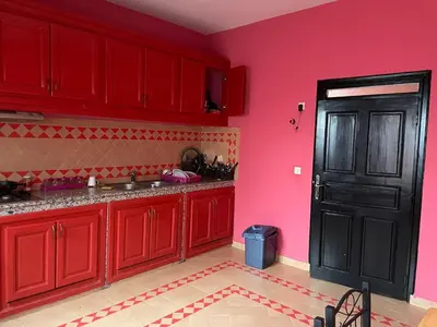 a kitchen with red cabinets and a black door at Riad Marrakech Ourika in Marrakech