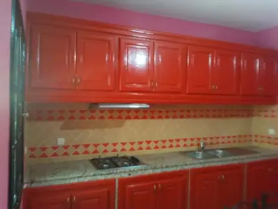 a red kitchen with red cabinets and a sink at Riad Marrakech Ourika in Marrakech