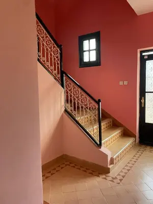 a staircase in a house with red walls and a window at Riad Marrakech Ourika in Marrakech