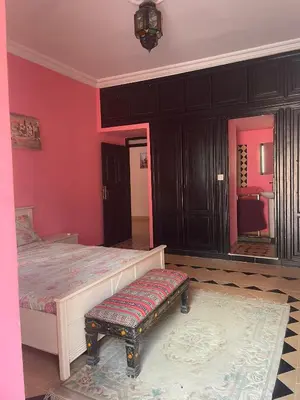 a bedroom with a large bed with red walls at Riad Marrakech Ourika in Marrakech