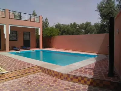 a swimming pool in the backyard of a house at Riad Marrakech Ourika in Marrakech