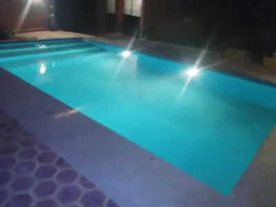 a swimming pool with lights on top of it at Riad Marrakech Ourika in Marrakech