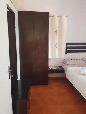 a bedroom with two beds and a cabinet in it at Appart Bin Elouidane in Bine el Ouidane