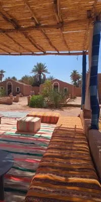 a rug laying on the ground under a roof at Kasbah Desert Camp in Mhamid