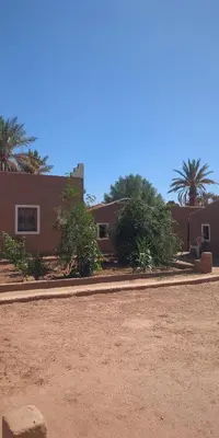 a house with a dirt road in front of it at Kasbah Desert Camp in Mhamid