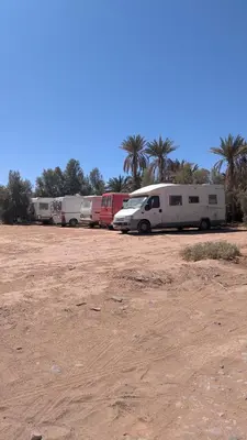 a row of camper vans parked in a field at Kasbah Desert Camp in Mhamid