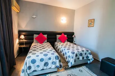 two beds sitting next to each other in a bedroom at Hotel De La Paix in Fès