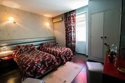 a bedroom with a bed and a couch and a window at Hotel De La Paix in Fès
