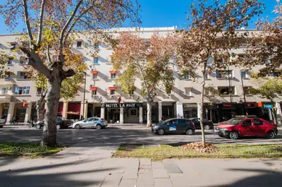 a parking lot with cars parked in front of a building at Hotel De La Paix in Fès