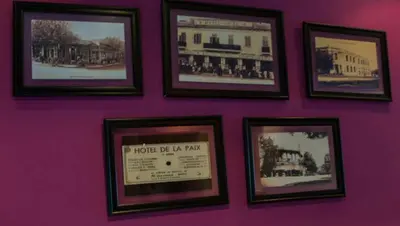 a wall with a bunch of pictures on it at Hotel De La Paix in Fès