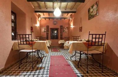 a restaurant with tables and chairs in a room at La Porte du Dades in Boumalne