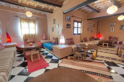 a living room with couches and tables and chairs at La Porte du Dades in Boumalne
