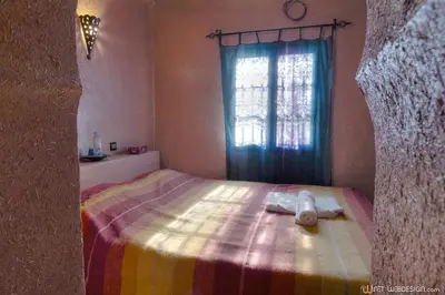 a bedroom with a bed with a stuffed animal on it at La Porte du Dades in Boumalne
