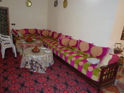 a living room with a couch and a table at gîte les jardins in Goulmima