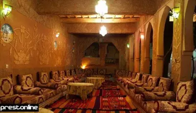 a lobby with couches and tables in a room at Riad Berbère Boutaghrar in Bou Tharar