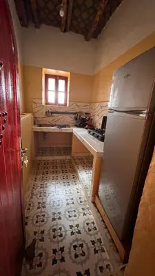 a small kitchen with a refrigerator and a window at Appartement belkacem in Merzouga