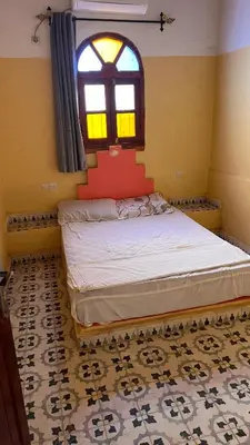 a small bedroom with a bed and a window at Appartement belkacem in Merzouga