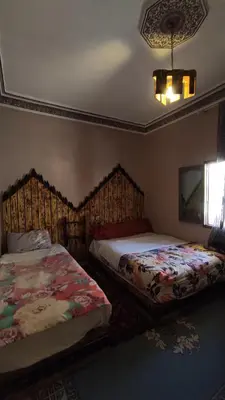 a bedroom with two beds and a window at Myhouse Todgha in Tinerhir