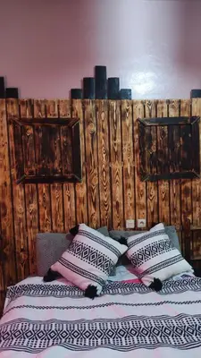 a bed with three pillows on top of it at Myhouse Todgha in Tinerhir