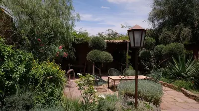 a garden with a table and chairs and a street light at Asnouss in Marrakech