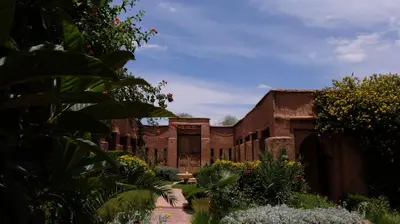 an old building with a courtyard with flowers and plants at Asnouss in Marrakech