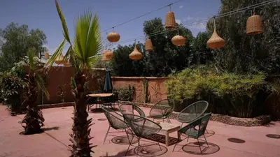 a patio with a table and chairs and lights at Asnouss in Marrakech