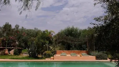 a backyard with a pool and a fence and trees at Asnouss in Marrakech