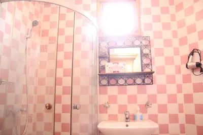 a bathroom with a shower and a sink and a mirror at Maison d'hôtes Dar El Nath in Ouarzazate