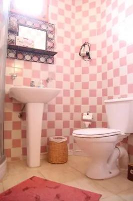 a pink bathroom with a sink and a toilet at Maison d'hôtes Dar El Nath in Ouarzazate