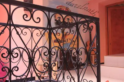 a wrought iron gate with a painting on the wall at Maison d'hôtes Dar El Nath in Ouarzazate