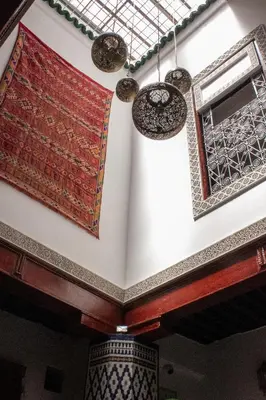 a room with carpets on the wall and a window at Dar Lantana in Fès