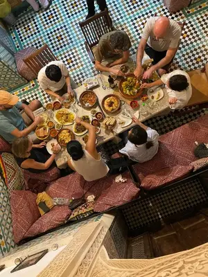 a group of people sitting around a table eating food at Dar Sunrise Fes in Fès