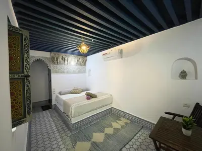 a bedroom with a bed in the corner of a room at Dar Sunrise Fes in Fès