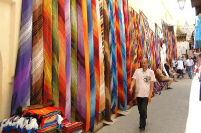 a man walking past a row of ties on a wall at Luxury Riad Saad Fes- Apart in Fès