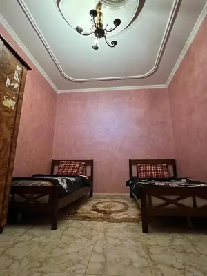 a room with two beds and a ceiling with a chandelier at 