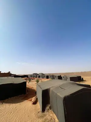 a group of huts in the middle of the desert at Mhamid Sahara Luxury Camp - Chez Naji in Mhamid