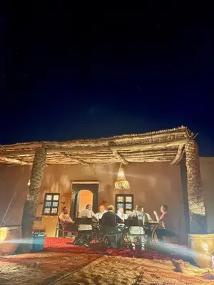 a group of people sitting in chairs outside of a building at Mhamid Sahara Luxury Camp - Chez Naji in Mhamid