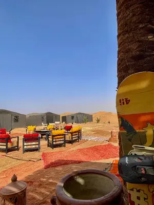 a group of tables and chairs in front of tents at Mhamid Sahara Luxury Camp - Chez Naji in Mhamid