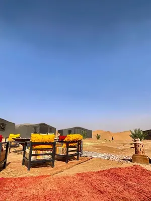 a picnic table and chairs in the desert at Mhamid Sahara Luxury Camp - Chez Naji in Mhamid