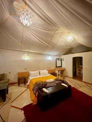 a bedroom with a bed in a tent at Mhamid Sahara Luxury Camp - Chez Naji in Mhamid