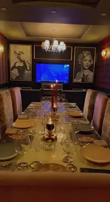 a table with wine glasses on it in a restaurant at Hotel Malta in Meknès