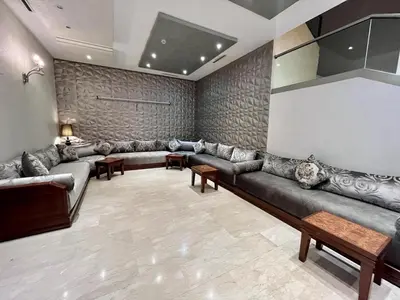 a large living room with couches and a wall at Hotel Malta in Meknès