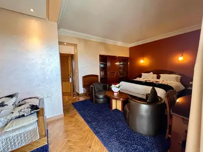a hotel room with a bed and leather furniture at Hotel Malta in Meknès