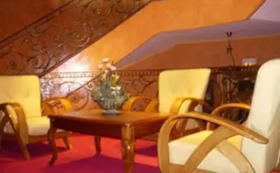 a dining room with a wooden table and chairs at Hotel Malta in Meknès