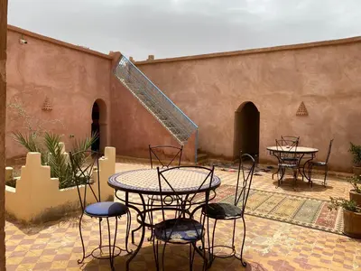 a patio with tables and chairs in a courtyard at Auberge Kasbah Des Dunes in Merzouga