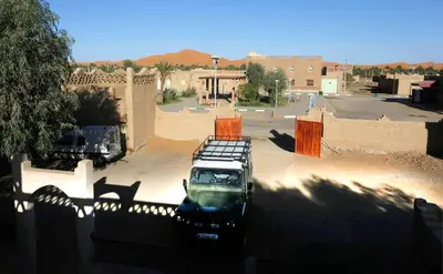a truck parked in a parking lot in front of a building at Auberge Kasbah Des Dunes in Merzouga