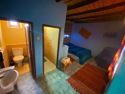 a bathroom with a sink and a toilet and a mirror at Auberge Kasbah Des Dunes in Merzouga