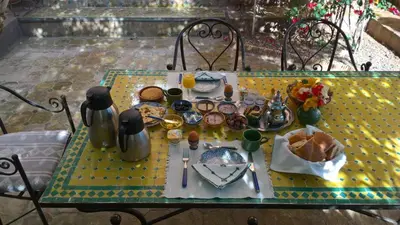 a table with a plate of food on it at Dar Nakhla Zagora Guest House Restaurant & Desert Excursions in Zagora